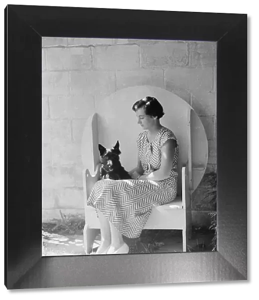 Mrs. Walter Fletcher with dog, seated outdoors, between 1933 and 1942. Creator: Arnold Genthe