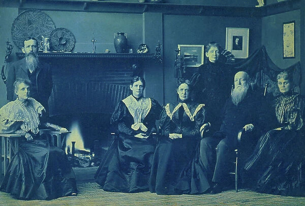 Frances Benjamin Johnston posed with six members of her family, by fireplace, in her Wash... 1896. Creator: Frances Benjamin Johnston