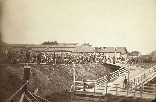 Group of convicts at head of inclined plane leading to barge, between 1885 and 1886. Creator: Unknown