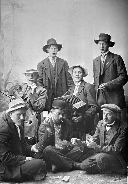 Group photo of men with musical instruments and playing cards, 1915. Creator: Unknown