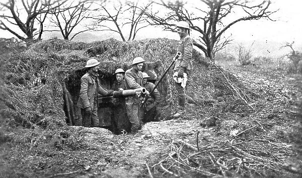Les Americains en Ligne; Une piece de 75, sous son camouflage, et ses servants americains, 1917. Creator: Unknown