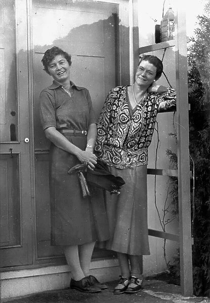 Mrs. Mary Benson and Alice DeLamar, standing by the door of a house, 1933. Creator: Arnold Genthe