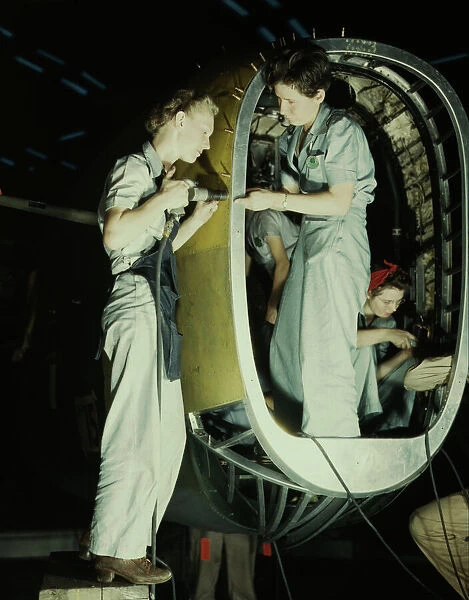 Riveters at work on fuselage of Liberator... Consolidated Aircraft Corp. Fort Worth, Texas, 1942. Creator: Howard Hollem