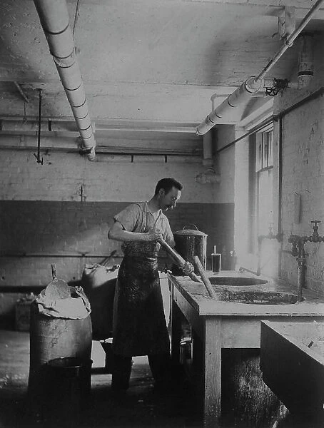 Worker prepares gum for postage stamps in the Stamp Division at the Bureau of Engraving... c1895. Creator: Frances Benjamin Johnston