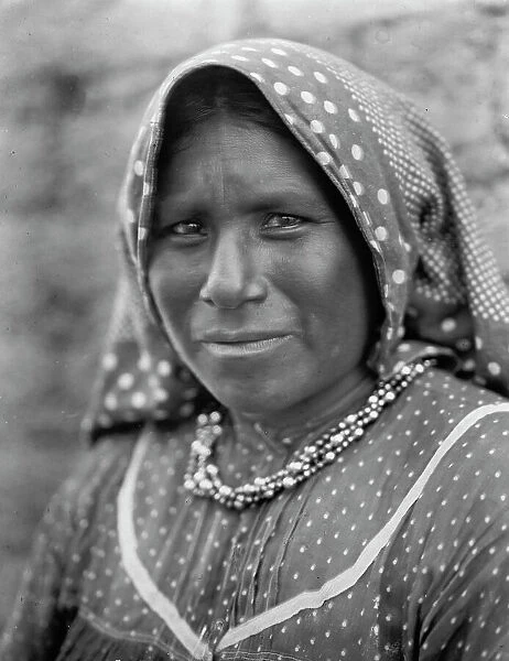 Yaqui matron, head-and-shoulders portrait, facing slightly left, wearing printed cotton... c1907. Creator: Edward Sheriff Curtis