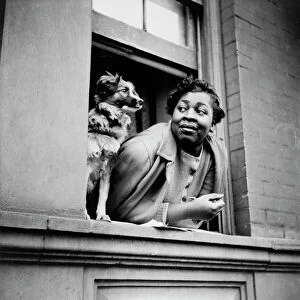 A woman and her dog in the Harlem section, New York, 1943. Creator: Gordon Parks