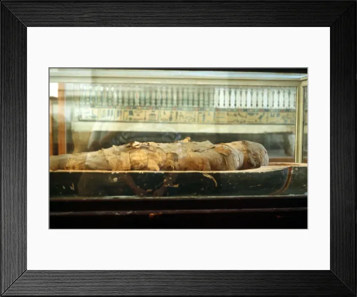 Framed Print : Mummy wrapped in bandages and lying on the base of a coffin, Ancient Egyptian Framed Print : Mummy wrapped in bandages and lying on the base of a coffin, Ancient Egyptian