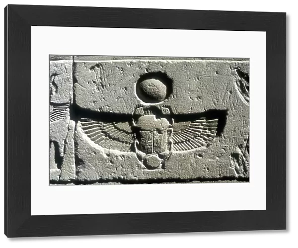 Limestone relief of a scarab beetle and vulture wings under a disk of the sun, Edfu, Egypt