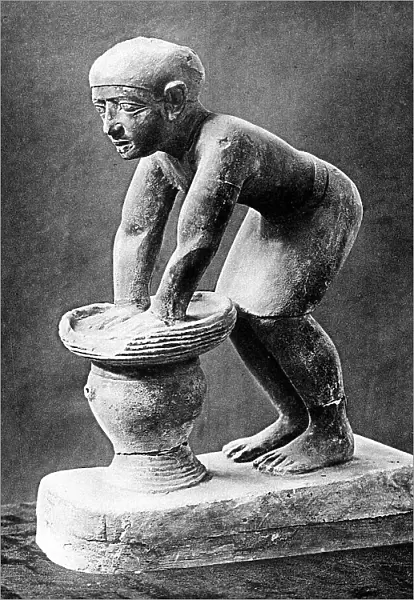 Figure of an Ancient Egyptian brewer pressing out fermented bread in a basket, c1910