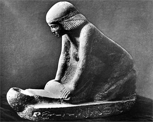 Egyptian tomb figure of a woman grinding corn using a saddle quern, c2500 BC