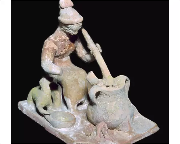Greek terracotta statuette of a woman cooking