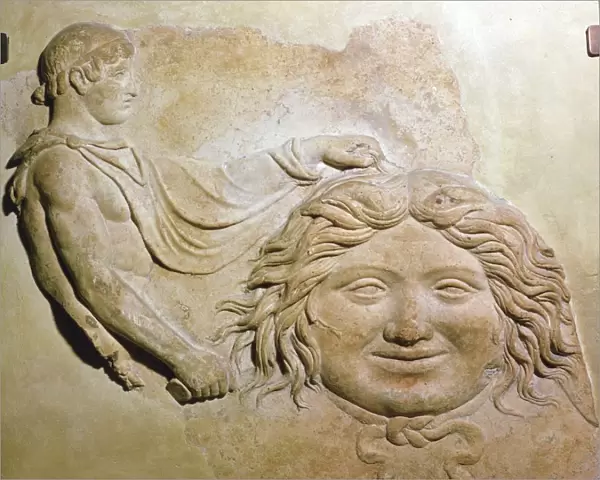 Roman fragment of a terracotta Campana relief showing head of Medusa with figure of Perseus