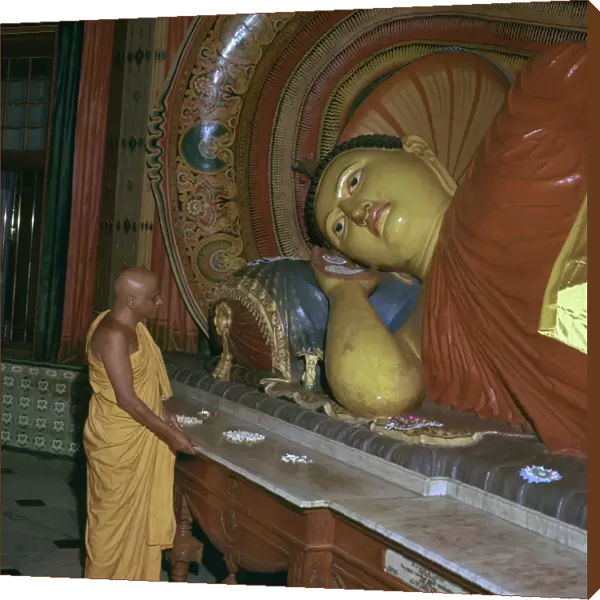 Buddhist priest before the image of a reclining Buddha