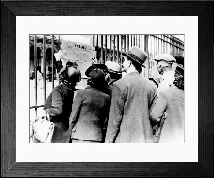 Framed Print : Refugees studying a train timetable, Gare de l Est, Paris, July 1940 Framed Print : Refugees studying a train timetable, Gare de l Est, Paris, July 1940