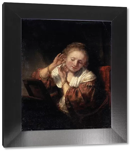 Young Woman trying on Earrings, 1657. Artist: Rembrandt Harmensz van Rijn