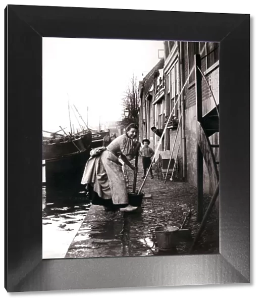 Woman mopping the street, Dordrecht, Netherlands, 1898. Artist: James Batkin