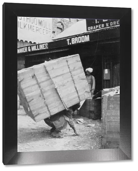 A porter lifting a large load, Chakrata, India, 1917