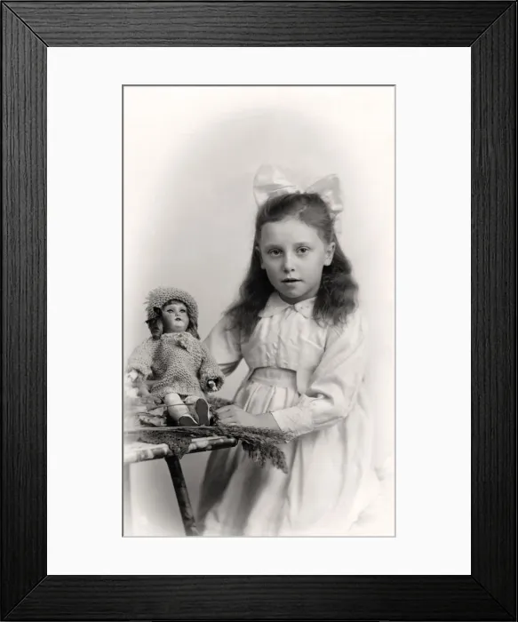 Framed Print : A young girl holding a doll, 20th century Framed Print : A young girl holding a doll, 20th century