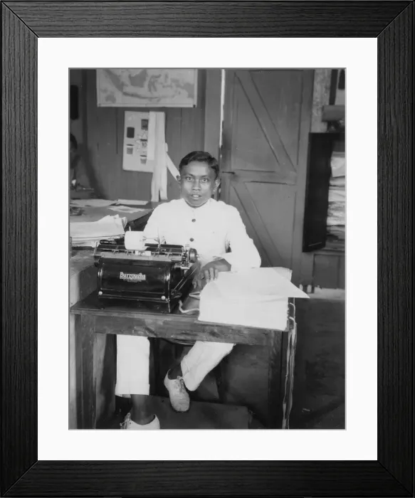 Framed Print : A young man sitting at a typewriter, Indonesia, 20th century Framed Print : A young man sitting at a typewriter, Indonesia, 20th century