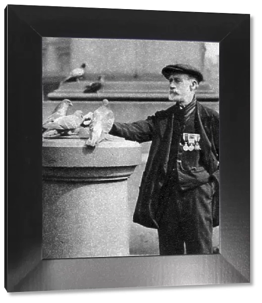 An old soldier with some pigeons, Trafalgar Square, London, 1926-1927. Artist: McLeish