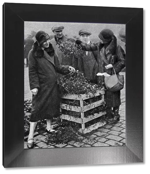 Women choosing bunches of mistletoe, Caledonian Market, London, 1926-1927