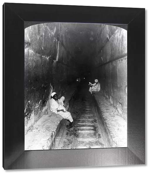 Looking down the main passage to Khufus sepulchre within the Great Pyramid, Egypt, 1905. Artist: Underwood & Underwood