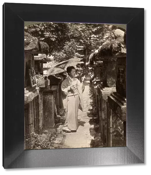 A woman Shinto devotee counting the stone lanterns, Kasuga Shrine, Nara, Japan, 1904. Artist: Underwood & Underwood