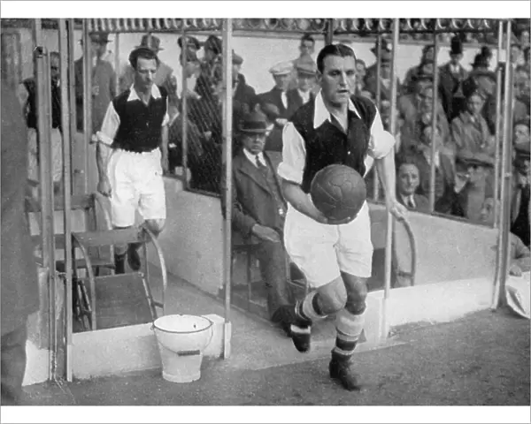 Arsenal FC captain Eddie Hapgood runs onto the pitch at Highbury, London, 1930s. Artist: Barratts Photo Press Ltd