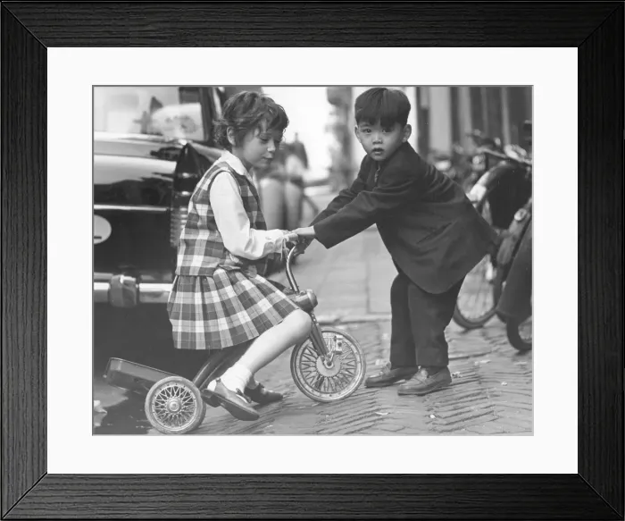 Framed Print : Children playing with a tricycle, c1960s Framed Print : Children playing with a tricycle, c1960s