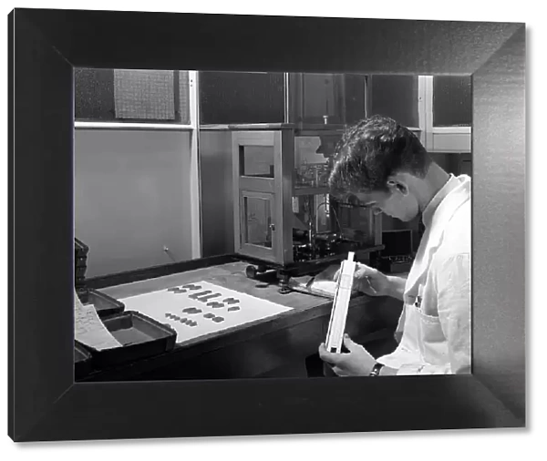 Lab technician with a slide rule, Edgar Allens steel foundry, Sheffield, South Yorkshire, 1962