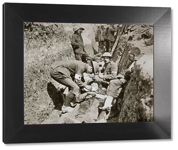 Red Cross men in the trenches tend a wounded man, Somme campaign, France, World War I, 1916