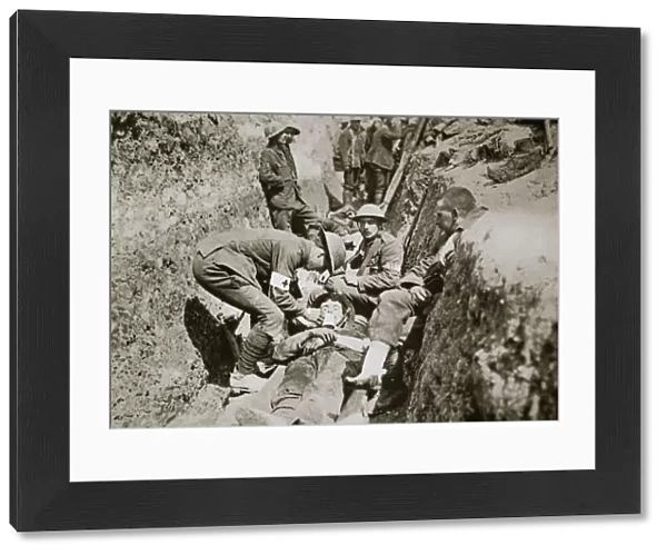 Red Cross men in the trenches tend a wounded man, Somme campaign, France, World War I, 1916