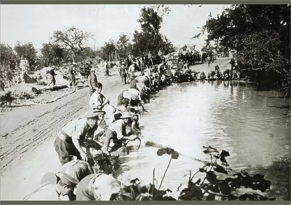 Transport men cleaning their harness at a pond after wet weather, France, World War I, 1916