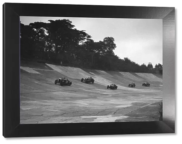 Cars racing on the banking at a JCC Members Day, Brooklands. Artist: Bill Brunell