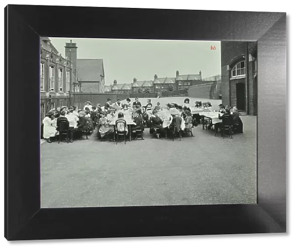 Children eating dinner at tables in the playground, Shrewsbury House Open Air School, London, 1908