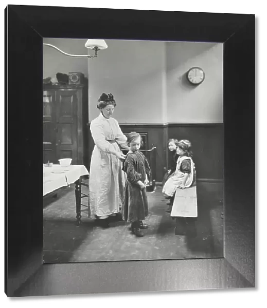 Nurse examining children before cleansing, Chaucer Cleansing Station, London, 1911