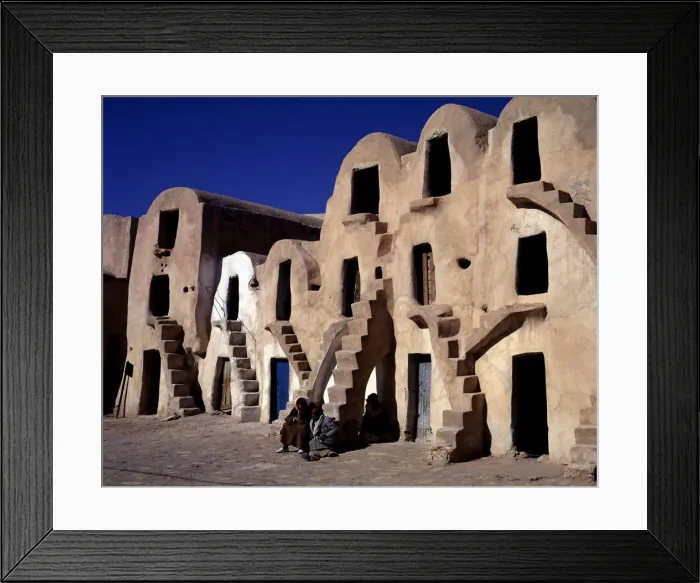 Framed Print : Old typical barns with people sitting on the stairs Framed Print : Old typical barns with people sitting on the stairs