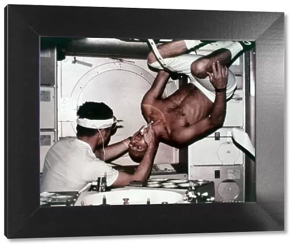 Kerwin examining Conrad on Skylab 2, 1973. Creator: NASA