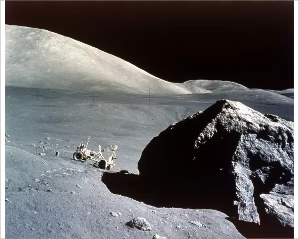 The Rover is dwarfed by a giant rock on the lunar surface, Apollo 17 mission, December 1972