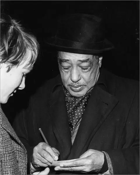 Duke Ellington signing his autograph, c1962. Creator: Brian Foskett