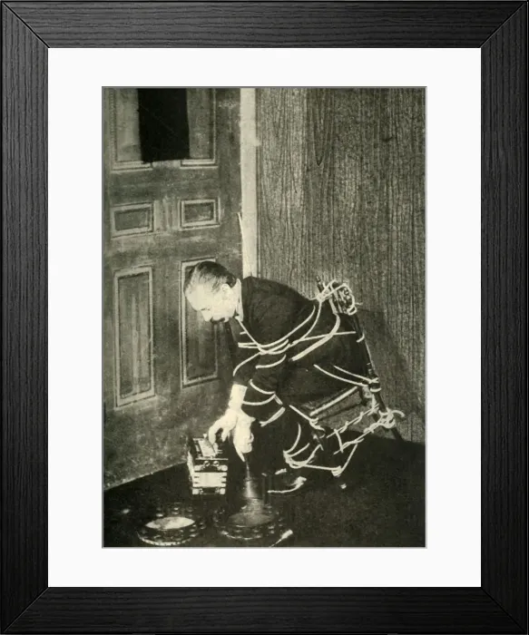 Framed Print : John Nevil Maskelyne performs a spirit cabinet illusion, c1910. Creator: Unknown Framed Print : John Nevil Maskelyne performs a spirit cabinet illusion, c1910. Creator: Unknown