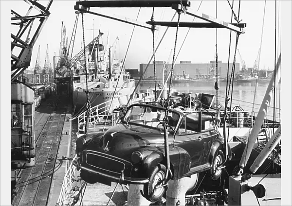 Morris Minor convertible craned onto ship for export at Cardiff docks. Creator: Unknown