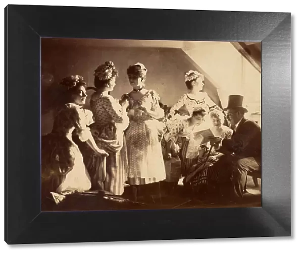 A Group of Six Costumed Women Posed in Interior with Top Hatted Gentlemen, c1885