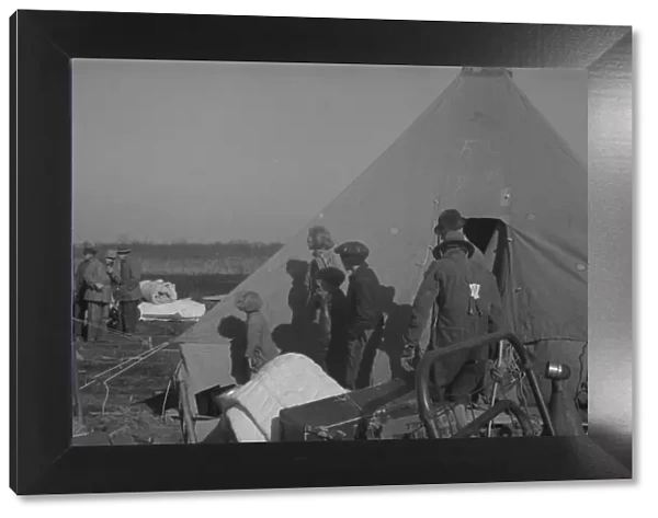 Possibly: Setting up a tent in the camp for white flood refugees, Forrest City, Arkansas, 1937. Creator: Walker Evans