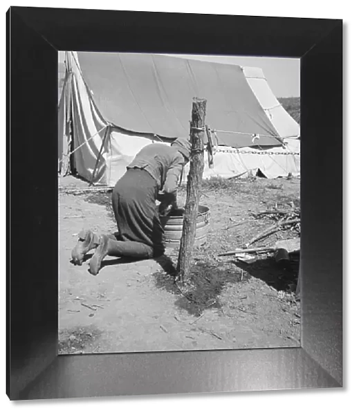 A grandmother washing clothes in California, in a contractors camp near Westley, California, 1939. Creator: Dorothea Lange