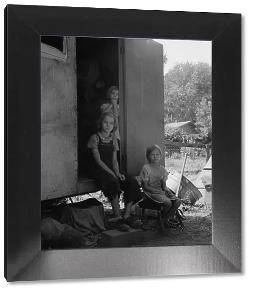 The oldest girl seated in the doorway of the house trailer... Yakima Valley, Washington, 1939. Creator: Dorothea Lange