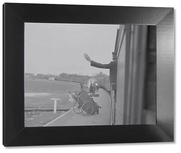 Trainman signalling from a 'Jim Crow'coach, Saint Augustine, Florida, 1943. Creator: Gordon Parks