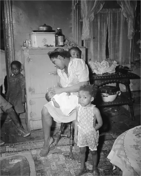 A mother getting the children ready for a neighborhood birthday party, Washington, D. C. 1942. Creator: Gordon Parks