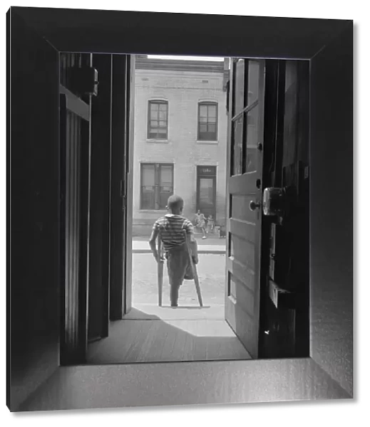 Young boy standing in the doorway of his home on Seaton Road... Washington, D.C, 1942. Creator: Gordon Parks