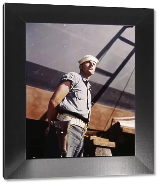 Coast Guardsman standing watch over 78-foot torpedo... Higgins Industries, Inc. New Orleans, 1942. Creator: Howard Hollem